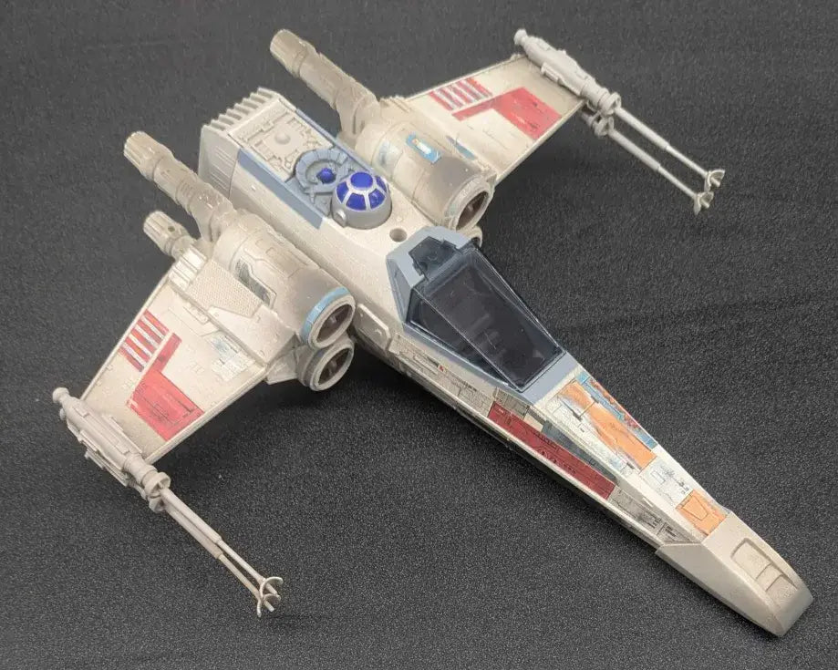 Off-white Star Wars Toy X-Wing Fighter with red and orange markings from 1995 Tonka