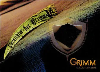 Curved yellow banner with German text beside a shield emblem on Grimm 2013 Scythe Blade trading card