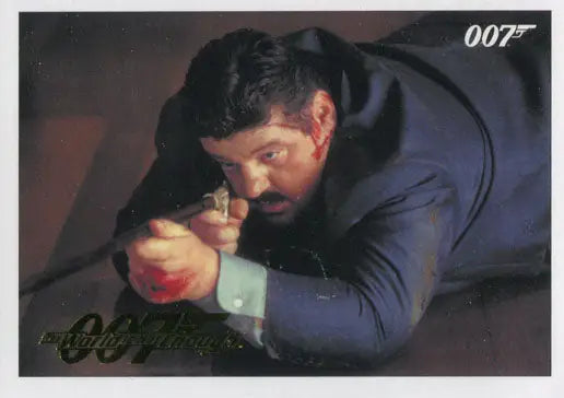 Man in a dark suit aiming a handgun in James Bond 007 gold parallel trading card