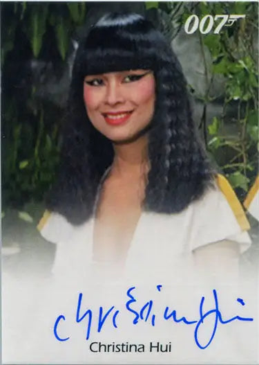 Smiling woman with long dark hair in white top on James Bond Autograph Card