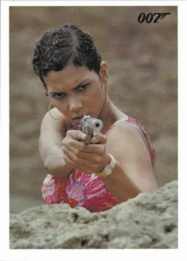 Woman in a pink top aiming a handgun in James Bond Archives 2017 promo card