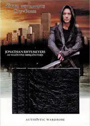 Jonathan Rys Meyers in dark clothing on textured surface with urban skyline backdrop