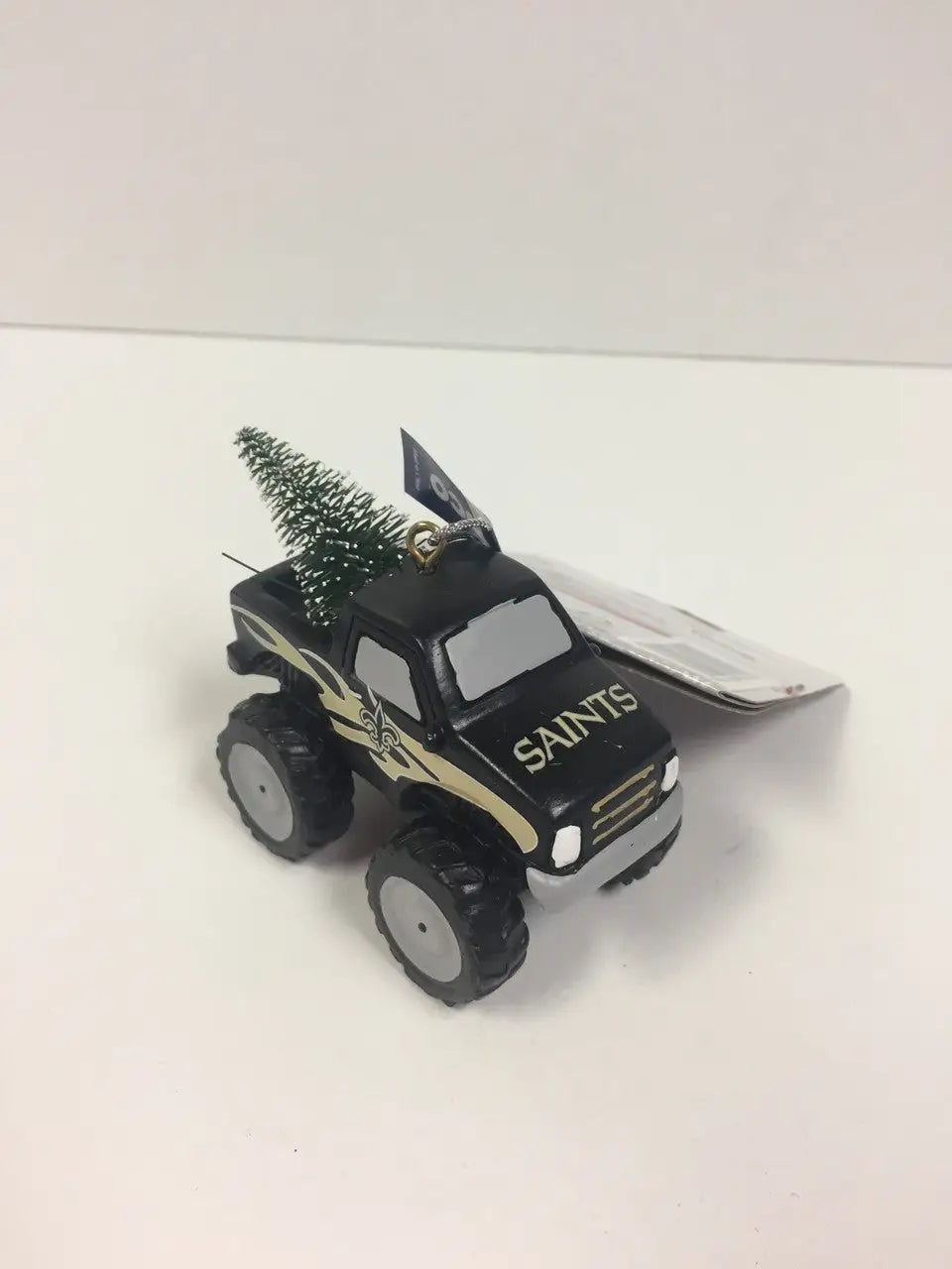 Toy monster truck ornament with SAINTS design and Christmas tree in the bed
