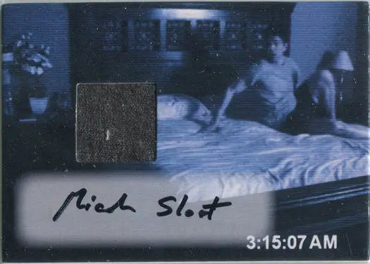 Shirtless person on bed in dim light with Paranormal Activity Autograph Wardrobe Card