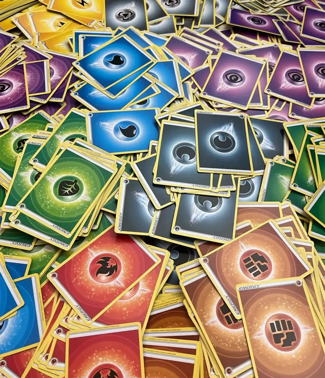 Collection of colorful Pokémon TCG energy cards in a pile for trading and gameplay