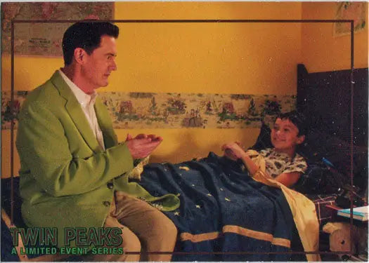 Man in green jacket sits by bed of child, featured in Rittenhouse 2019 trading cards