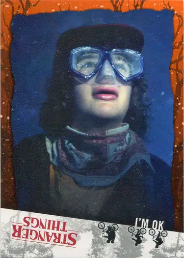 Person in ski goggles and winter clothing against blue background, showcasing orange parallel trading card