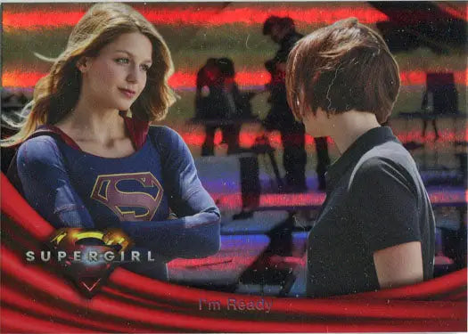 Two people talking, one in a Supergirl costume, featuring a rainbow foil board design