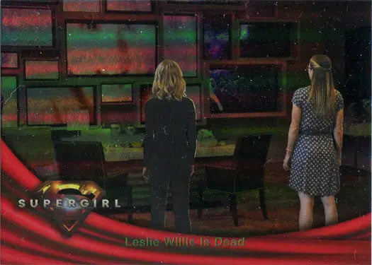 Two women in a television studio with vibrant display screens and rainbow foil board