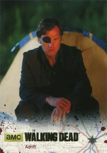 Person in black outfit and eyepatch beside tent on Walking Dead gold parallel trading card