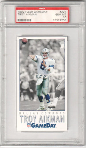 1992 fleer gameday troy aikman trading card, graded psa 10 by the dallas cowboys quarterback in a black-and-white action shot with his number 8 jersey and helmet.