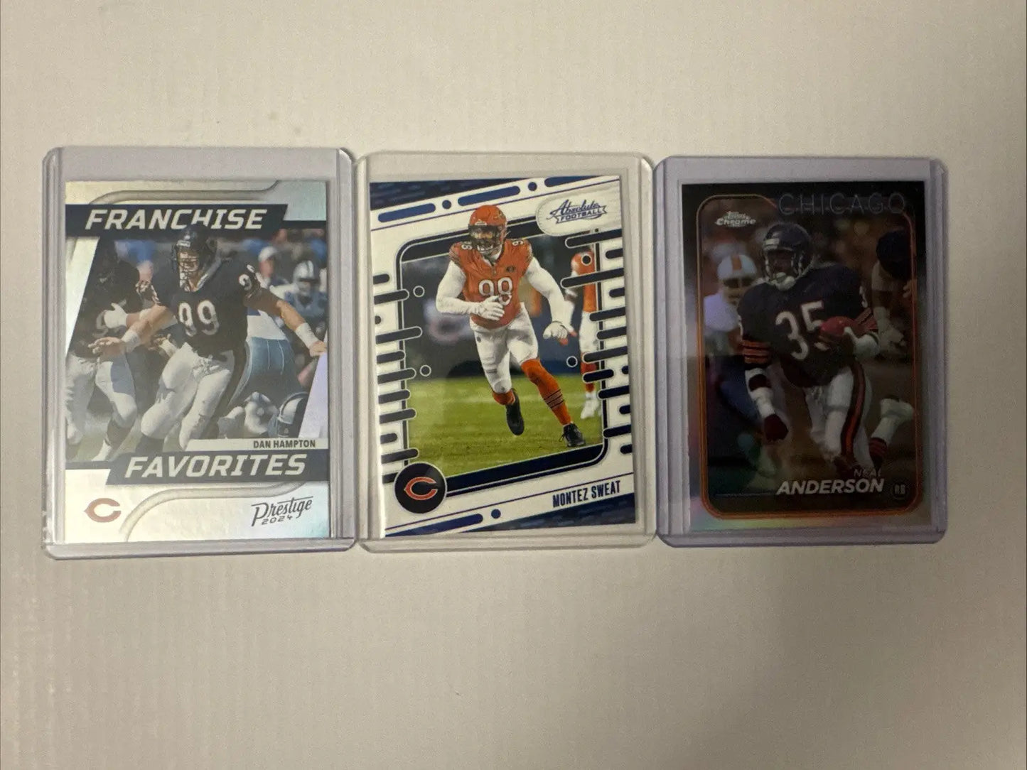Three Chicago Bears football trading cards in clear cases featuring William Perry and Devin Hester