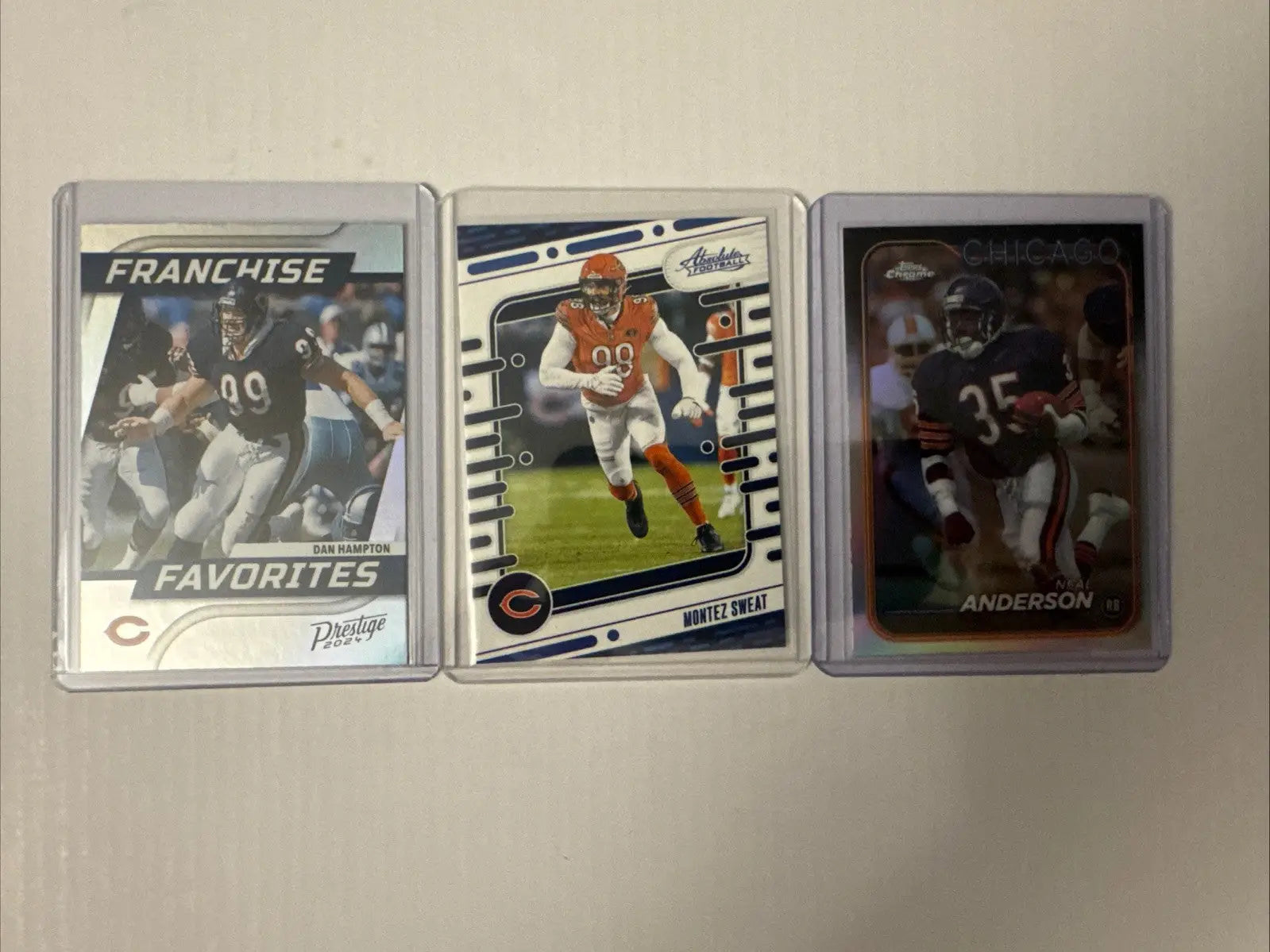 Three Chicago Bears football trading cards in clear cases featuring William Perry and Devin Hester