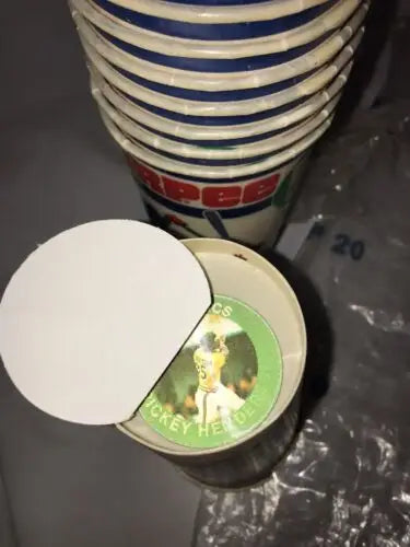 Stack of Pepsi cups and sports disc with 1985 Original Slurpee Cup and baseball cards