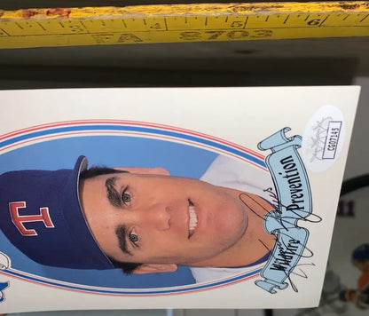 Autographed baseball card of Kenny Rogers in a Texas Rangers blue cap with red T emblem