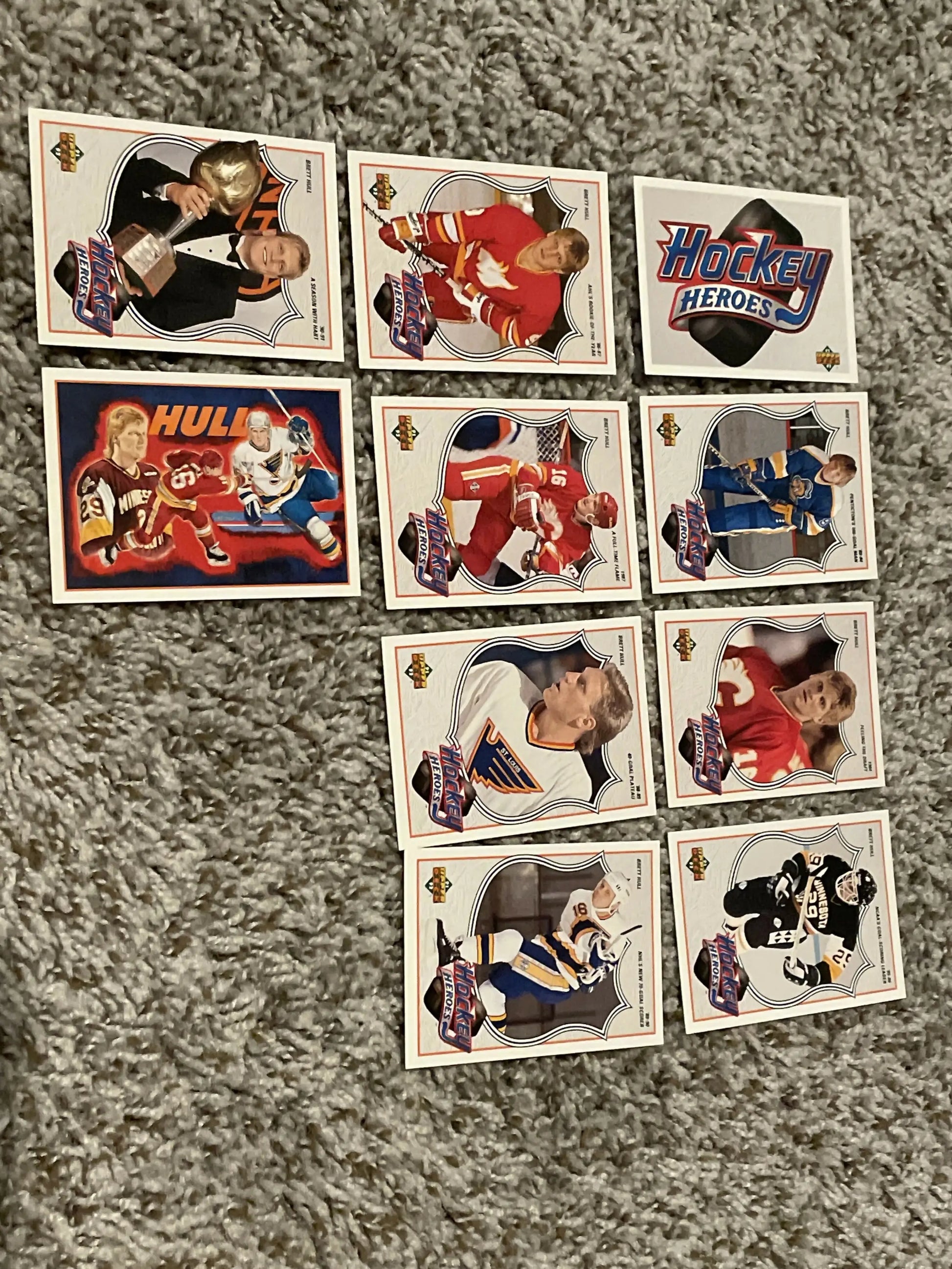Vintage hockey trading cards displayed on a carpet, featuring the 1991-92 Upper Deck Brett Hull Heroes