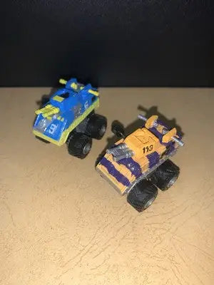 Two toy micro machines monster trucks from the 1991 Galoob MICRO MACHINES Wind-Up CRANKERS Tank Lot
