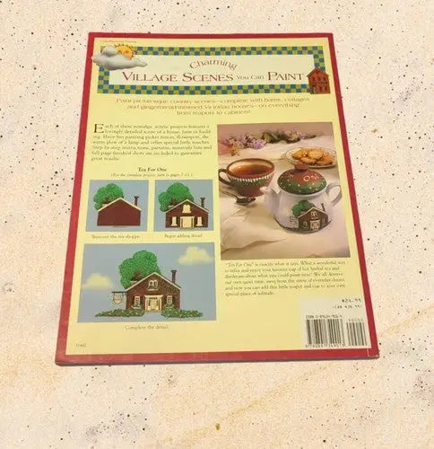 Charming village scenes painting book by Catherine Holman on store shelf pulls