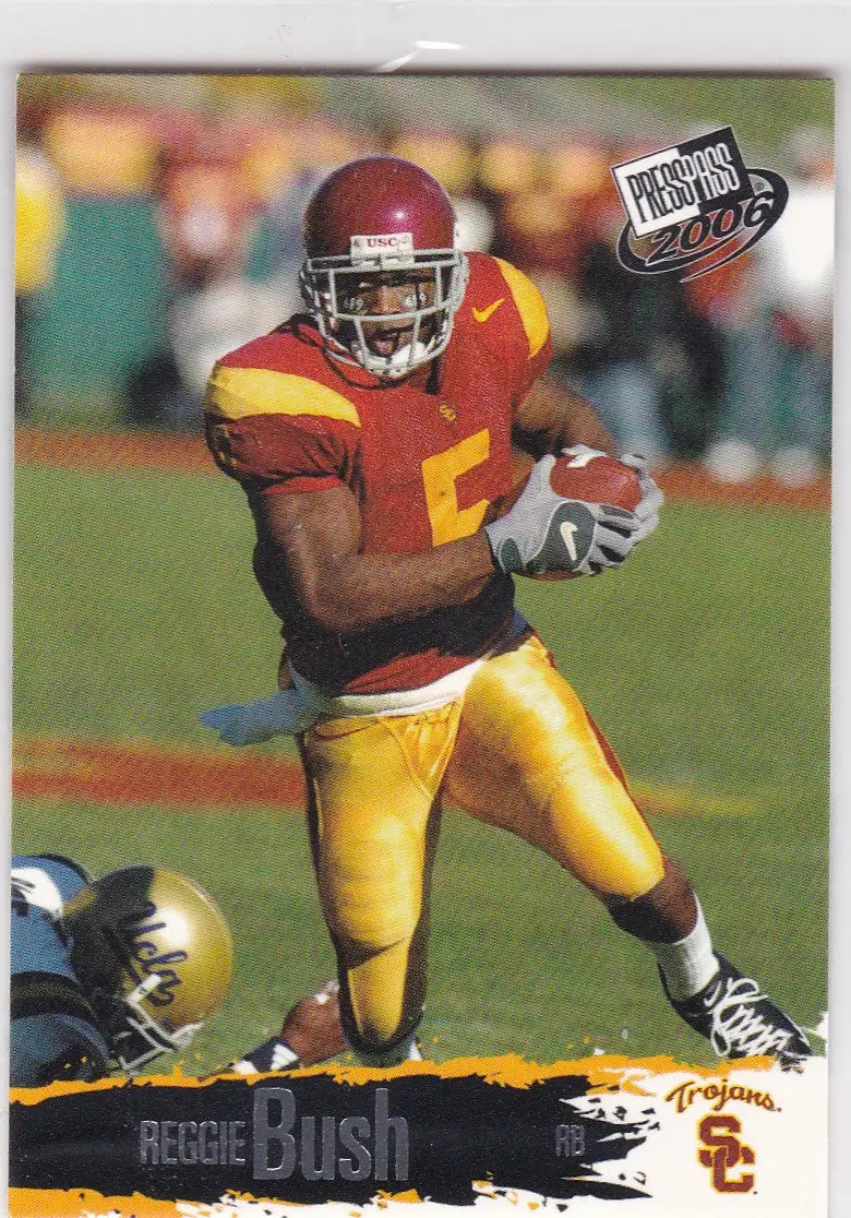 USC football player Reggie Bush RC2 in cardinal and gold uniform carrying the ball