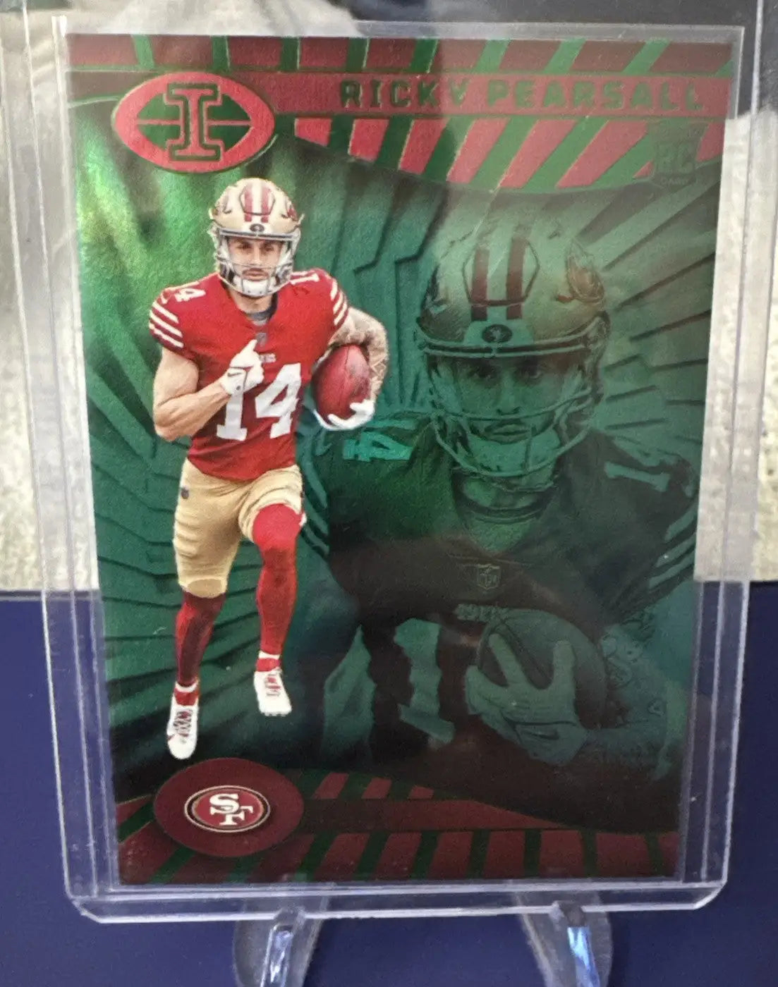 Sports trading card featuring a 49ers player in red and gold on illusions emerald green background
