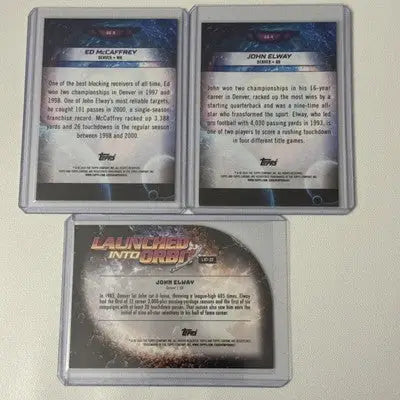 Three football trading cards in protective cases from Topps Chrome Cosmic Galaxy Greats collection