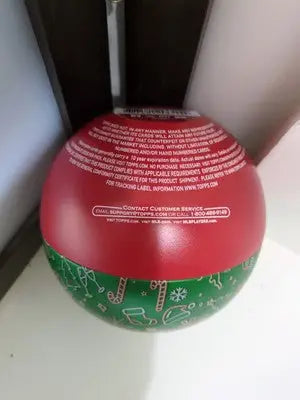 Red and green Christmas ornament on Topps Holiday empty tin for holiday decor