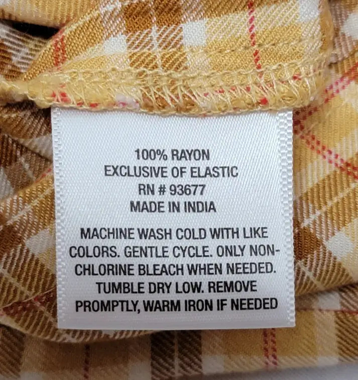 Clothing care label for 90s yellow plaid mini dress made in India with washing and ironing instructions