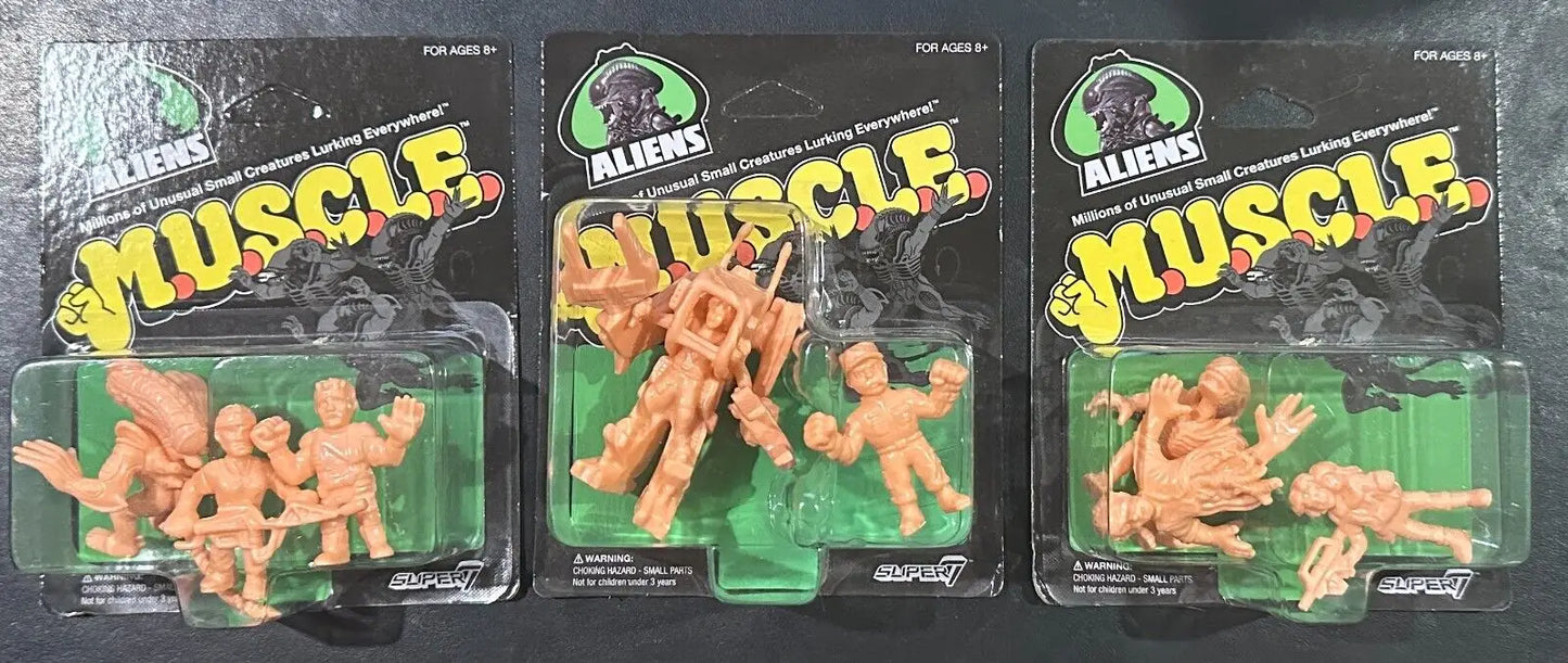 Three packages of Aliens Muscle figures from Super7 showcasing collectible trading cards