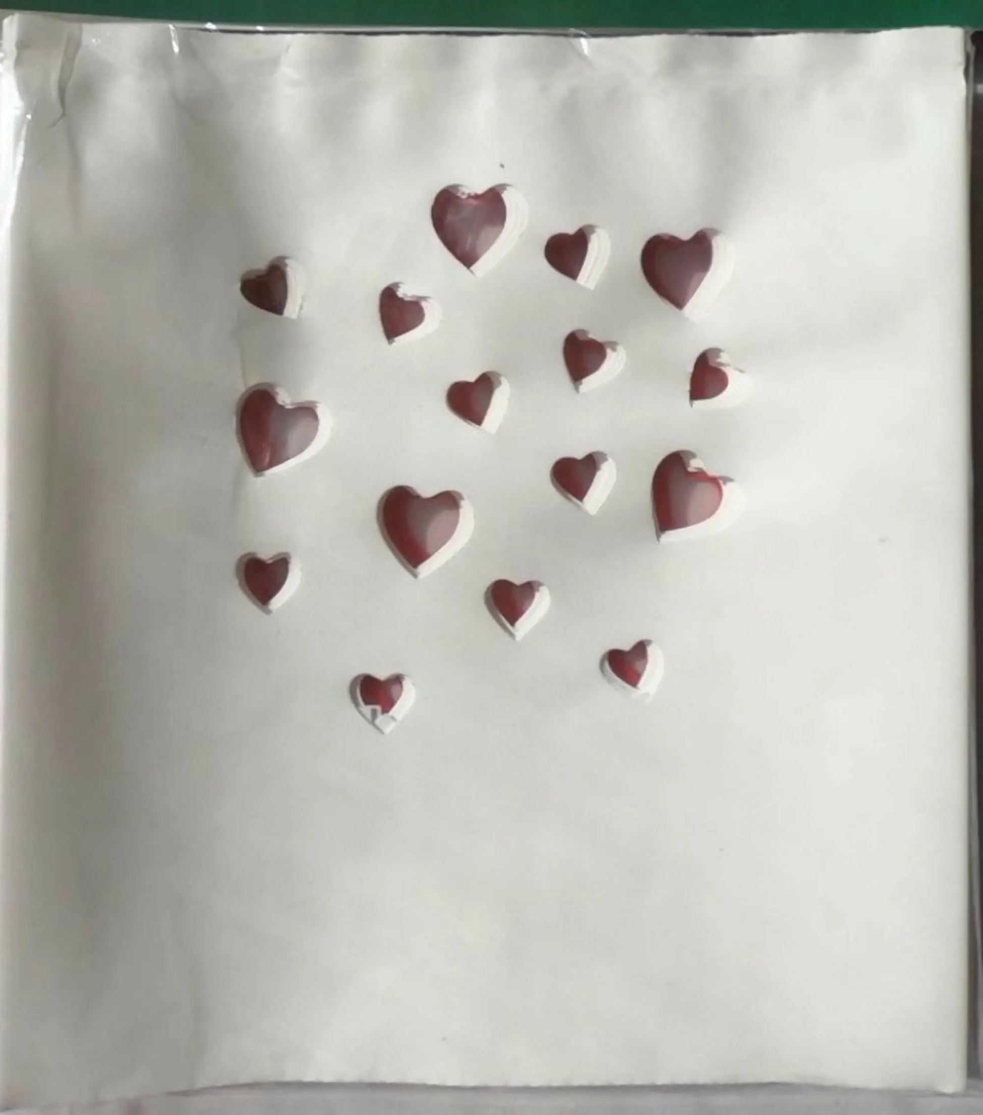 White luminarias bag with red heart cutouts, perfect for electric luminarias and bag clips