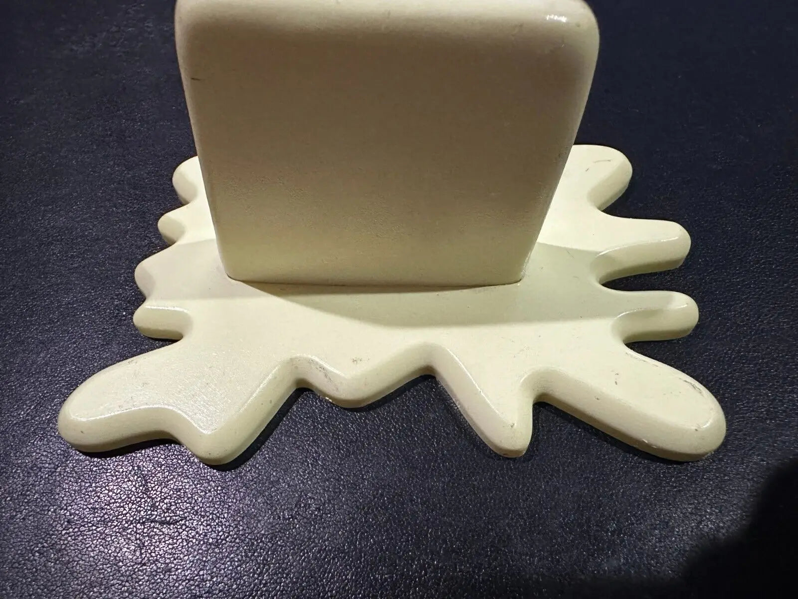 Cream-colored blocky object on splash-shaped base for Butter Barrage Accessory