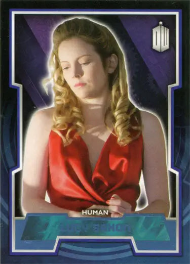 Woman with blonde curly hair in a red top holding Doctor Who Blue Foil Parallel Card