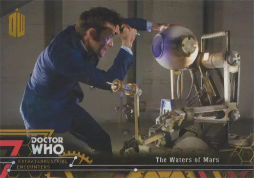 Person in a blue suit examines a robot device featured in Doctor Who Gold Parallel Chase