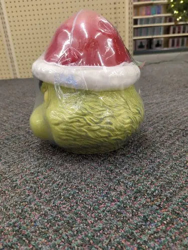 Wrapped Grinch head cookie jar with Santa hat, perfect for sleigh bell bistro Christmas decor