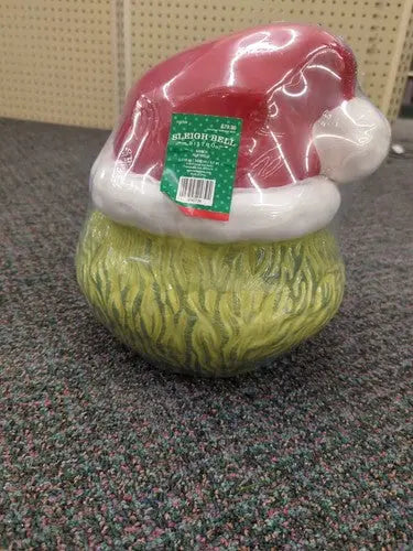 Grinch-themed ceramic cookie jar with Santa hat and sleigh bell bistro Christmas decor