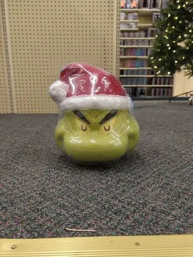 Green Grinch head cookie jar wearing a Santa hat with sleigh bell detail from Sleigh Bell Bistro