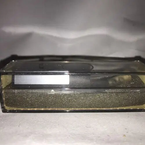 Rectangular transparent container of dark granular material for Head Needle Stylus NOS