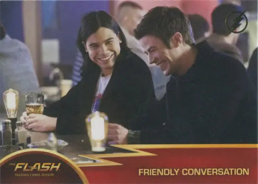 Two people smiling and talking at a table, featured in Flash Season 1 Gold Logo Parallel Chase Card
