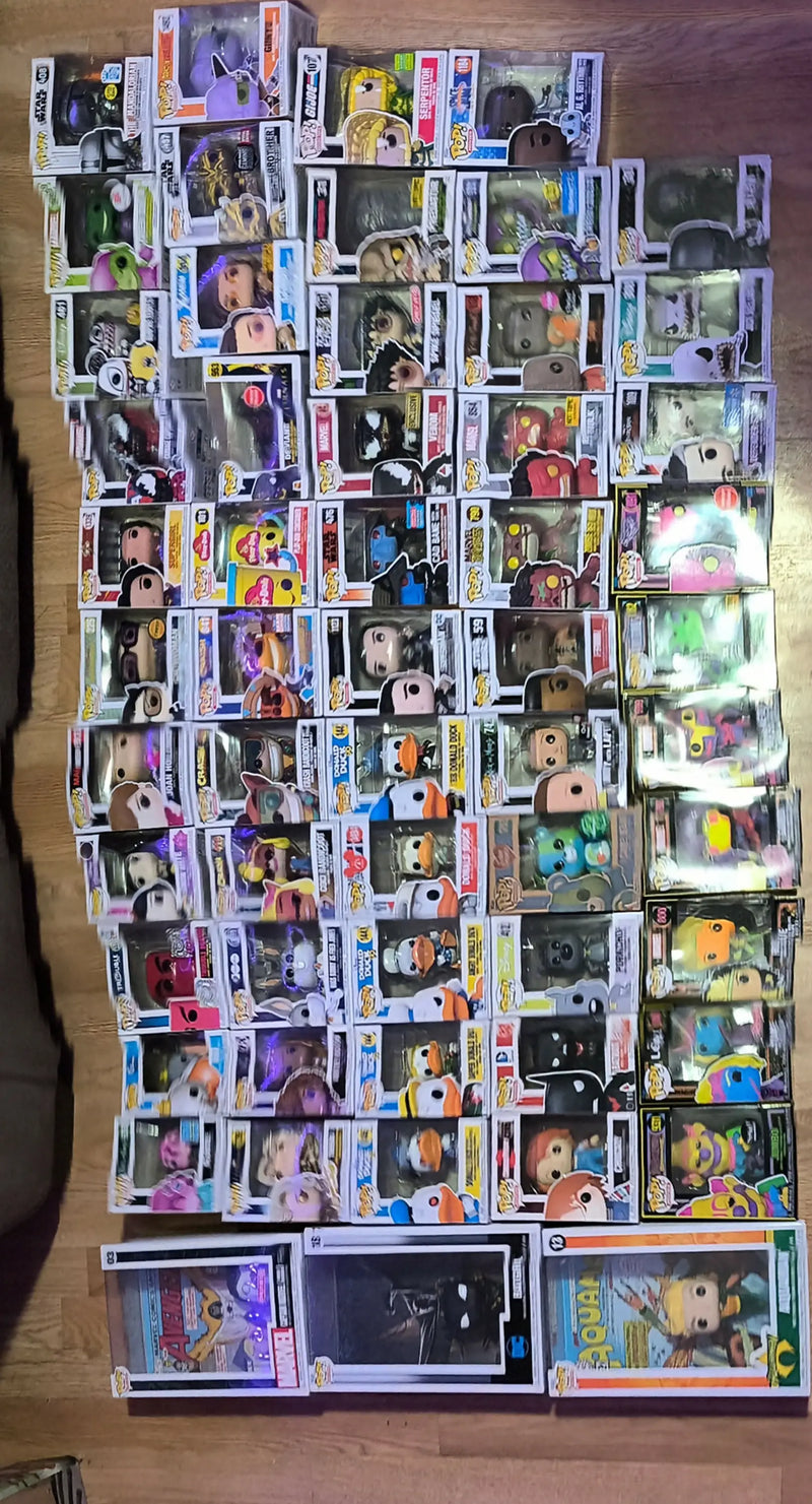Collection of boxed Funko Pops figures alongside trading cards and baseball cards