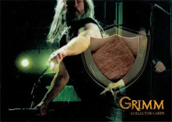 Long-haired person holds textured shield on stage for Grimm 2013 Prop Card spiked club