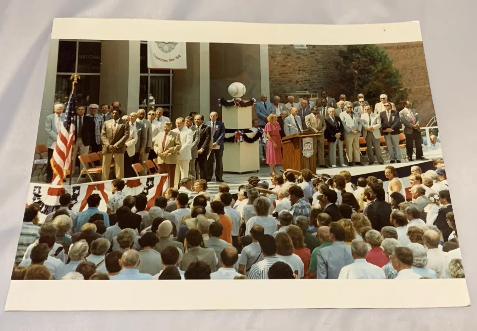Outdoor ceremony with crowd around stage featuring Johnny Bench sports memorabilia