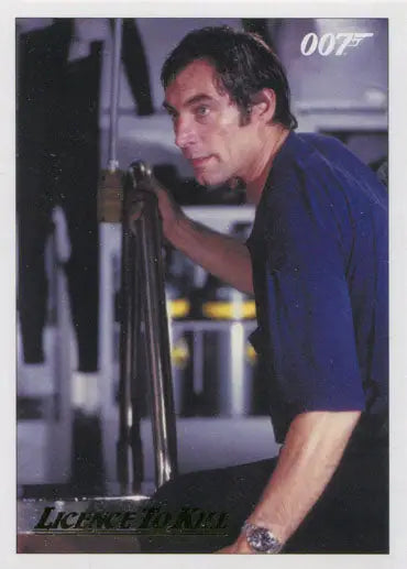Man in blue shirt intently gazing at James Bond 007 Gold Parallel Chase Card