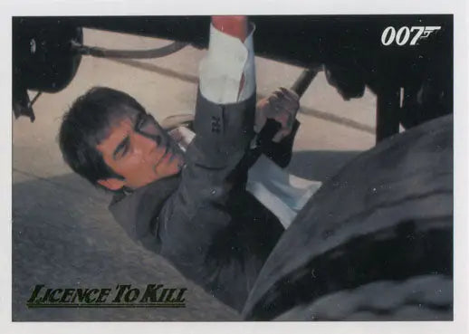 Man in suit hanging from aircraft in action scene, featured on James Bond 007 gold parallel chase card