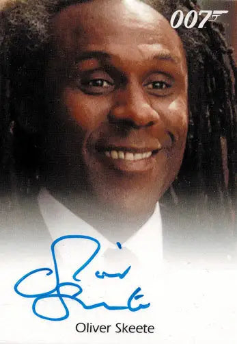 Smiling man in white shirt and dark jacket on James Bond Oliver Skeete Autograph Card