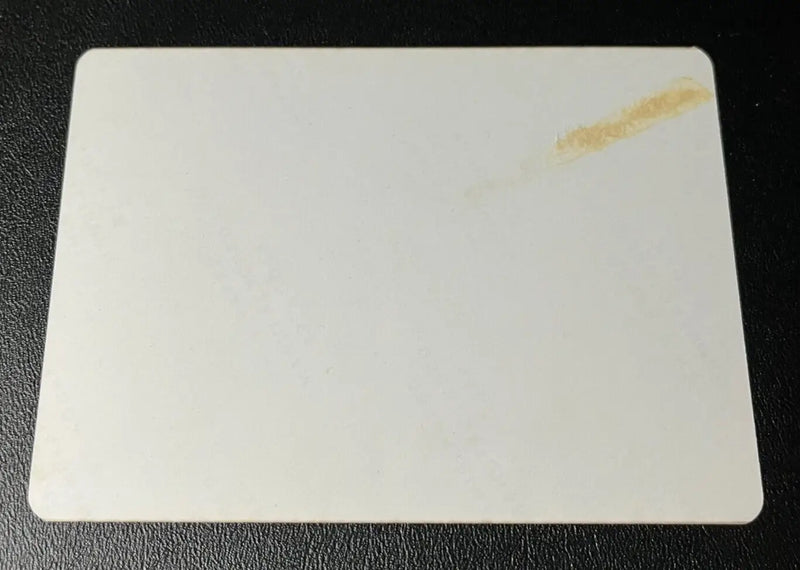 Rectangular white baseball card with rounded corners and a stain featuring Joe DiMaggio Yankees