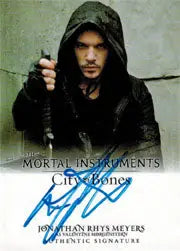 Person in dark hooded garment gazes intensely at camera on Jonathan Rys Meyers Autograph Card