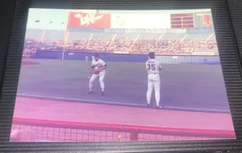 Nolan Ryan at Texas Rangers game, showcasing trading cards during pre-game action