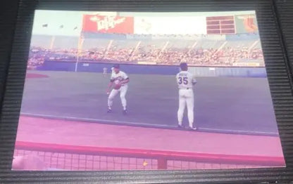 Nolan Ryan at Texas Rangers game, showcasing trading cards during pre-game action
