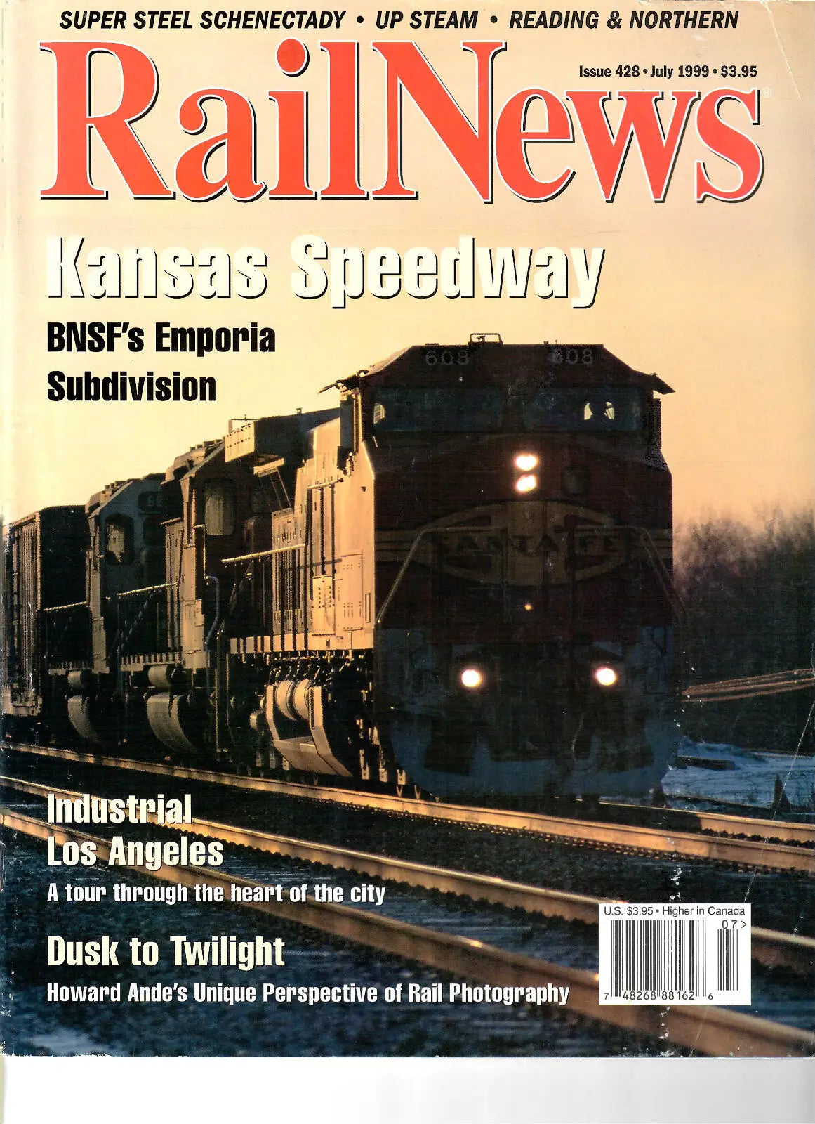 Magazine cover featuring a train at Kansas Speedway during dusk in RailNews #428 July 1999