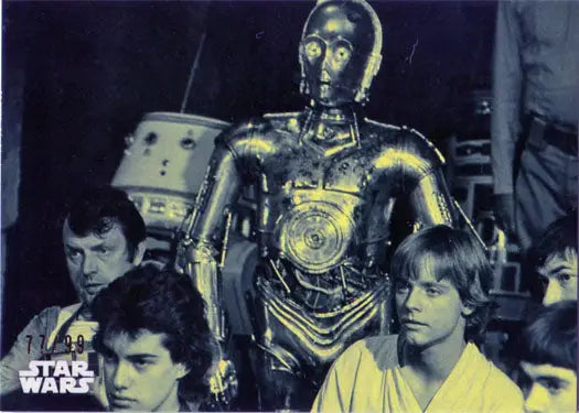 Golden humanoid robot with glowing eyes in Star Wars trading cards display