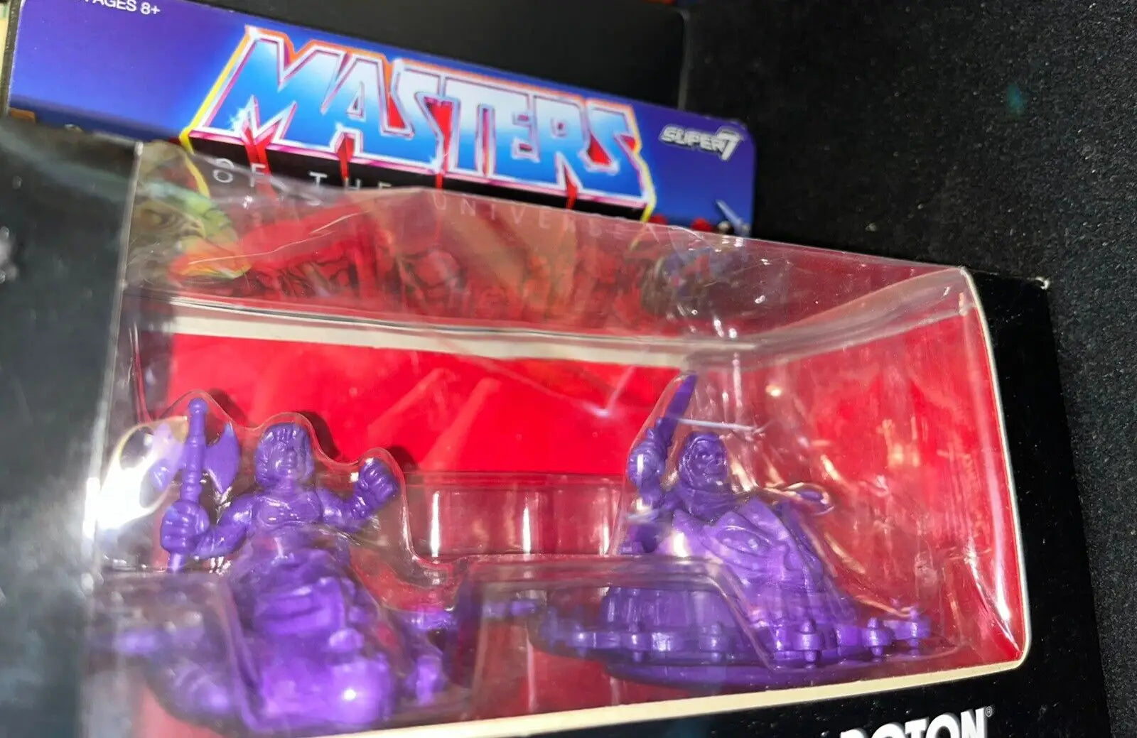 Two purple Masters of the Universe figures in packaging for Wind Raider collectibles